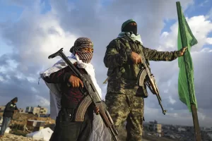 A boy holds a weapon as he stands next to a Hamas fighter standing in position ahead of handing over the bodies of four Israeli hostages, including a mother and her two children, who had long been feared dead, to the Red Cross in Khan Younis, southern Gaza Strip, Thursday, Feb. 20, 2025. (AP Photo/Jehad Alshrafi)


Associated Press/LaPresse