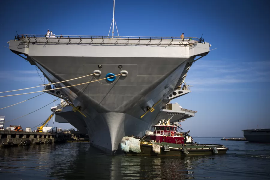 Tugboat Ft. Bragg gets into position to maneuver the USS Gerald R. Ford aircraft carrier out into the James River as the capital ship prepares to leave Naval Station Norfolk, Tuesday, June 24, 2025, in Norfolk, Va. (AP Photo/John Clark)