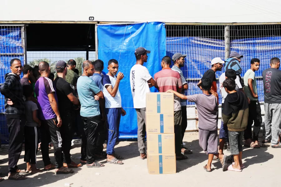 Palestinians line up to receive food delivered by the World Food Programme (WFP) in Khan Younis, southern Gaza Strip, Sunday, Nov. 2, 2025. (AP Photo/Jehad Alshrafi)