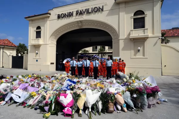 Police offer a salute after laying a wreath at a memorial for shooting victims outside the Bondi Pavilion at Sydney’s Bondi Beach, Monday, Dec. 15, 2025, a day after a shooting. (AP Photo/Mark Baker)
