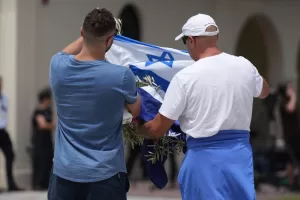 Men prepare to lay a wreath at a flower memorial outside Bondi Pavilion at Sydney’s Bondi Beach, Monday, Dec. 15, 2025, a day after a shooting. (AP Photo/Mark Baker)