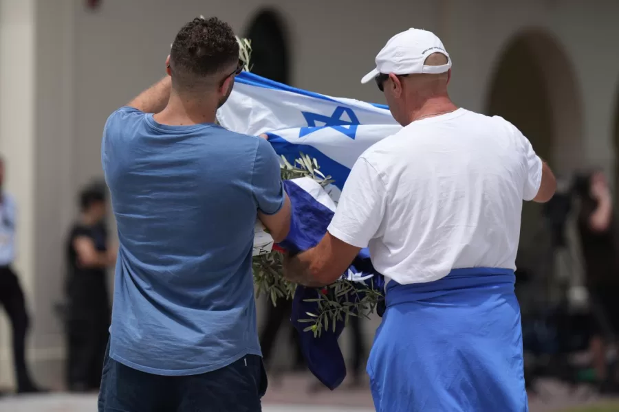 Men prepare to lay a wreath at a flower memorial outside Bondi Pavilion at Sydney’s Bondi Beach, Monday, Dec. 15, 2025, a day after a shooting. (AP Photo/Mark Baker)