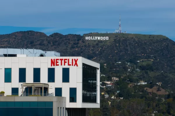 A Netflix sign is displayed atop a building in Los Angeles, Thursday, Dec. 18, 2025, with the Hollywood sign in the distance. (AP Photo/Jae C. Hong)