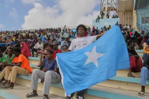 A man holds the flag of Somalia as people gather at the Mogadishu stadium while they protest Israel’s recognition of Somalia’s breakaway region of Somaliland as an independent nation, in Mogadishu, Somalia, Tuesday, Dec. 30, 2025. (AP photo/Farah Abdi Warsameh)