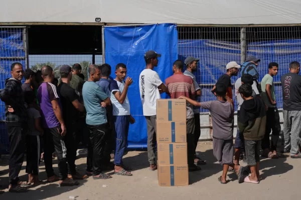 Palestinians line up to receive food delivered by the World Food Programme (WFP) in Khan Younis, southern Gaza Strip, Sunday, Nov. 2, 2025. (AP Photo/Jehad Alshrafi)