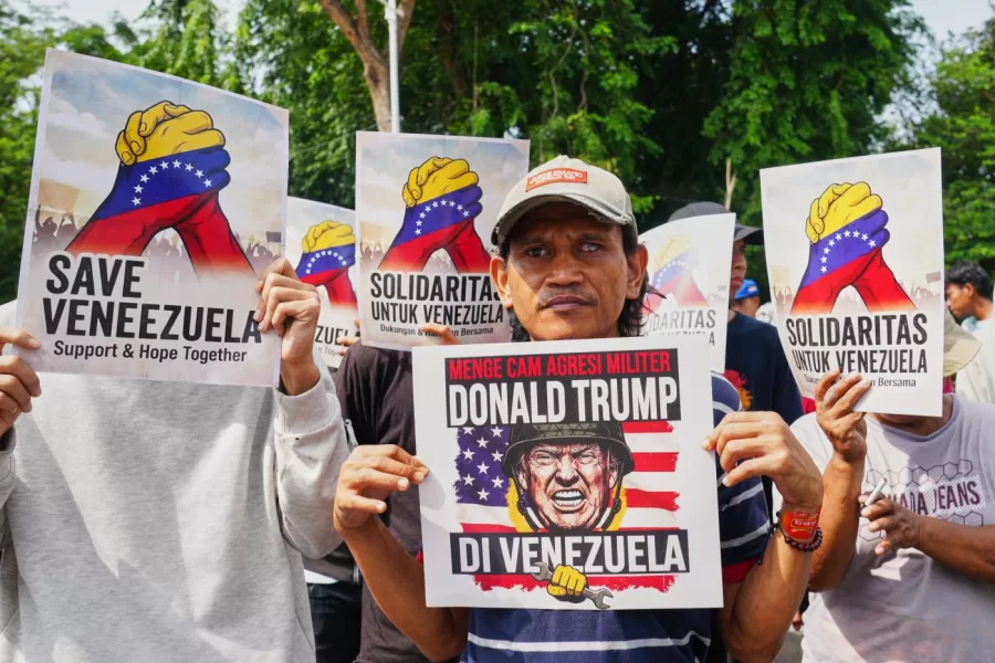 A protester holds a placard during a rally outside the U.S. Embassy in Jakarta, Indonesia denouncing the U.S.capture of Venezuelan President Nicolas Maduro, Tuesday, Jan. 6, 2026. Placard reads, “denounce Donald Trump’s military aggression in Venezuela”. (AP Photo/Tatan Syuflana)