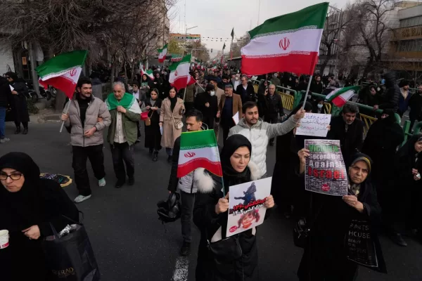 People carry Iranian flags and pro-government placards during a funeral ceremony for a group of security forces, who were killed during anti-government protests, in Tehran, Iran, Wednesday, Jan. 14, 2026. (AP Photo/Vahid Salemi)