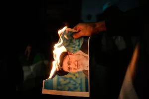 Demonstrators burn a poster depicting Iran’s Supreme Leader Ayatollah Ali Khamenei during a rally in support of anti-government protests in Iran, in Holon, Israel Wednesday, Jan. 14, 2026. (AP Photo/Ohad Zwigenberg)