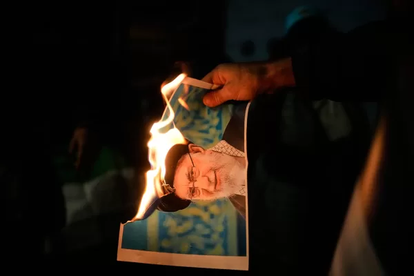 Demonstrators burn a poster depicting Iran’s Supreme Leader Ayatollah Ali Khamenei during a rally in support of anti-government protests in Iran, in Holon, Israel Wednesday, Jan. 14, 2026. (AP Photo/Ohad Zwigenberg)