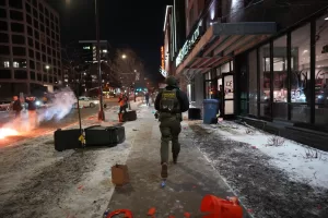 Federal agents run in to clear the hotel during a noise demonstration protest in response to federal immigration enforcement operations in the city Sunday, Jan. 25, 2026, in Minneapolis. (AP Photo/Adam Gray)
