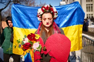 A woman wears a flowers crown as members of the Ukrainian community stage a protest to mark the fourth year since the start of Russia full scale invasion of Ukraine in Bucharest, Romania, Sunday, Feb. 22, 2026. (AP Photo/Vadim Ghirda) A woman wears a flowers crown as members of the Ukrainian community stage a protest to mark the fourth year since the start of Russia full scale invasion of Ukraine in Bucharest, Romania, Sunday, Feb. 22, 2026. (AP Photo/Vadim Ghirda)