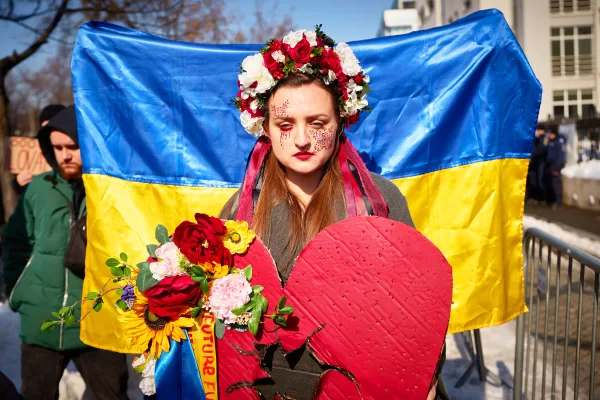 A woman wears a flowers crown as members of the Ukrainian community stage a protest to mark the fourth year since the start of Russia full scale invasion of Ukraine in Bucharest, Romania, Sunday, Feb. 22, 2026. (AP Photo/Vadim Ghirda)