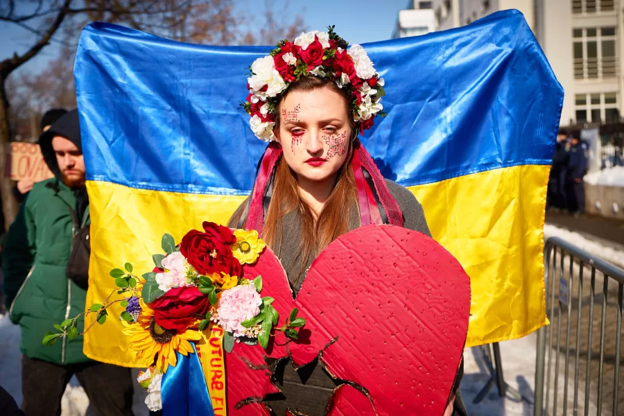 A woman wears a flowers crown as members of the Ukrainian community stage a protest to mark the fourth year since the start of Russia full scale invasion of Ukraine in Bucharest, Romania, Sunday, Feb. 22, 2026. (AP Photo/Vadim Ghirda)