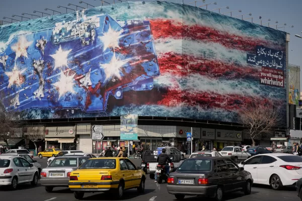 Vehicles pass a billboard depicting a U.S. aircraft carrier with damaged fighter jets on its deck and a sign in Farsi and English reading, “If you sow the wind, you’ll reap the whirlwind,” at Enqelab-e-Eslami (Islamic Revolution) Square in Tehran, Iran, Sunday, Feb. 22, 2026. (AP Photo/Vahid Salemi) 


Associated Press / LaPresse
Only italy and spain