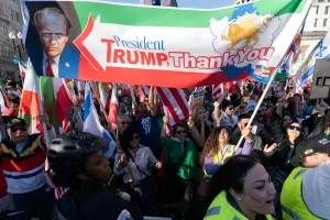 People who support the U.S. and Israel strikes on Iran, hold a banner with a photo of President Donald Trump during a rally near the White House, Saturday Feb. 28, 2026, in Washington. (AP Photo/Jose Luis Magana)