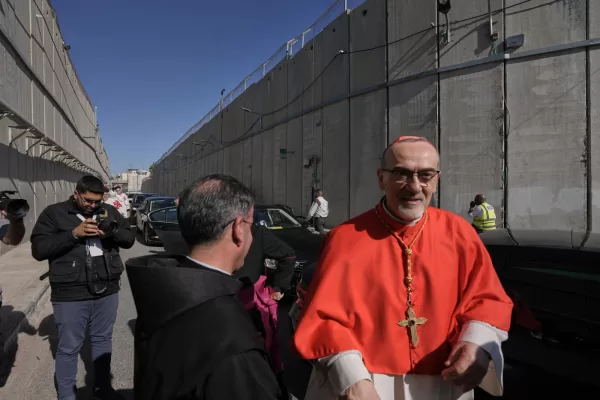Latin Patriarch Pierbattista Pizzaballa, the top Catholic clergyman in the Holy Land, is received by local community while crossing an Israeli military checkpoint from Jerusalem ahead of celebrations at the Church of the Nativity, traditionally believed to be the birthplace of Jesus, on Christmas Eve, in the West Bank city of Bethlehem, Wednesday, Dec. 24, 2025. (AP Photo/Mahmoud Illean)