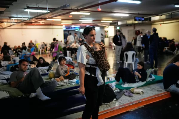 Leah Guttmann holds her son, Teddy, as other people take shelter in an underground parking garage while air-raid sirens warn of incoming missiles launched by Iran toward Tel Aviv, Israel, Sunday, March 1, 2026. (AP Photo/Ohad Zwigenberg) Leah Guttmann holds her son, Teddy, as other people take shelter in an underground parking garage while air-raid sirens warn of incoming missiles launched by Iran toward Tel Aviv, Israel, Sunday, March 1, 2026. (AP Photo/Ohad Zwigenberg)