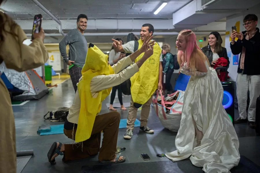 People attend a joint bachelor and bachelorette party in an underground parking garage, as a precaution against the threat of possible Iranian missile attacks in Tel Aviv, Israel, Tuesday, March 17, 2026. (AP Photo/Ohad Zwigenberg)