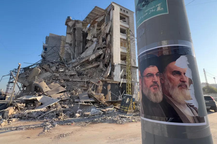 Portraits of late Hezbollah leader Sayyed Hassan Nasrallah and the late Iranian revolutionary founder Ayatollah Khomeini, are seen in front of a destroyed building that housed a branch of Al-Qard Al-Hassan, a non-bank financial institution run by Hezbollah, which was hit by an Israeli airstrike in Dahiyeh, Beirut’s southern suburbs, Lebanon, Tuesday, March 10, 2026. (AP Photo/Hussein Malla)