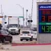Drivers navigate a busy intersection past a sign displaying the current gas prices at a filling station in Plano, Texas, Friday, March 6, 2026. (AP Photo/Tony Gutierrez)