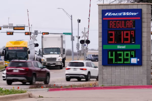 Drivers navigate a busy intersection past a sign displaying the current gas prices at a filling station in Plano, Texas, Friday, March 6, 2026. (AP Photo/Tony Gutierrez)