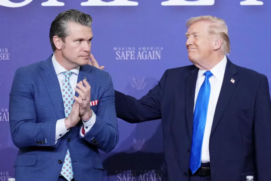 President Donald Trump speaks with Defense Secretary Pete Hegseth during a roundtable discussion on public safety at a Tennessee Air National Guard Base, Monday, March 23, 2026, in Memphis, Tenn. (AP Photo/Mark Schiefelbein)