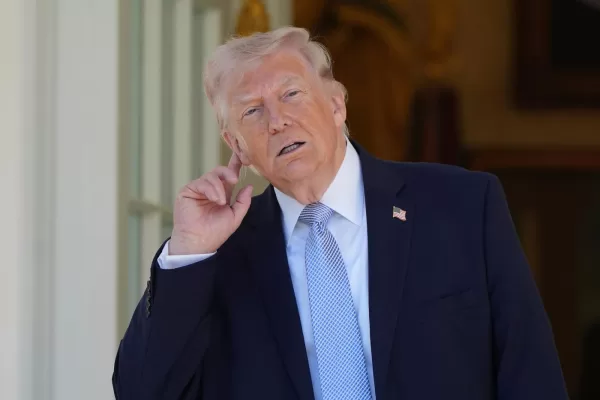 President Donald Trump holds his ear to listen to the music before heading back to the Oval Office after participating in the White House Easter Egg Roll on the South Lawn of the White House, Monday, April 6, 2026, in Washington. (AP Photo/Alex Brandon)