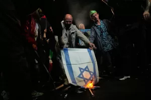 Iranian pro-government demonstrators burn an Israeli flag during a gathering after the announcement of a two-week ceasefire in the war with the Unites States and Israel, at the Enqelab-e-Eslami, or Islamic Revolution, Square in Tehran, Iran, Wednesday, April 8, 2026. (AP Photo/Vahid Salemi)