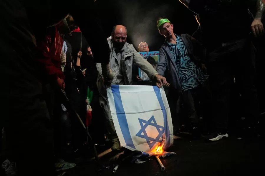 Iranian pro-government demonstrators burn an Israeli flag during a gathering after the announcement of a two-week ceasefire in the war with the Unites States and Israel, at the Enqelab-e-Eslami, or Islamic Revolution, Square in Tehran, Iran, Wednesday, April 8, 2026. (AP Photo/Vahid Salemi)