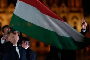 Peter Magyar, the leader of the opposition Tisza party waves a national flag after claiming victory in a parliamentary election in Budapest, Hungary, Sunday, April 12, 2026. (AP Photo/Darko Bandic)