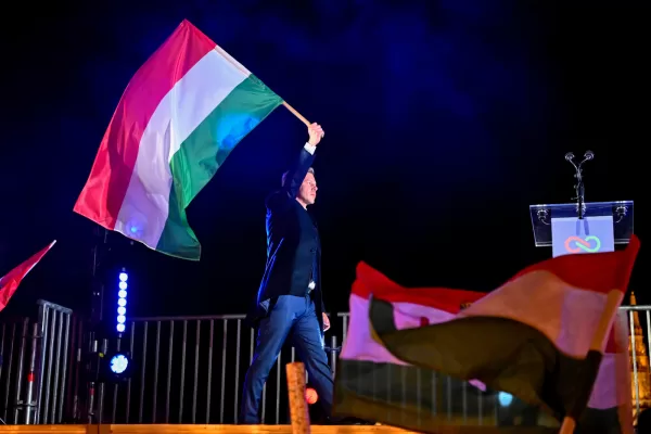 Peter Magyar, leader of the opposition Tisza party, waves the Hungarian flag following the announcement of the partial results of the parliamentary election, in Budapest, Hungary, Sunday, April 12, 2026. (AP Photo/Denes Erdos)