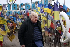In this Feb. 26, 2026, photo provided by Ukraine’s 65th Mechanized Brigade press service, Britain’s former Prime Minister Boris Johnson stands at the city entrance sign surrounded by Ukrainian national flags and flags of military units as he visits the frontline town of Orikhiv in the Zaporizhzhia region, Ukraine. (Andriy Andriyenko/Ukraine’s 65th Mechanized Brigade via AP)