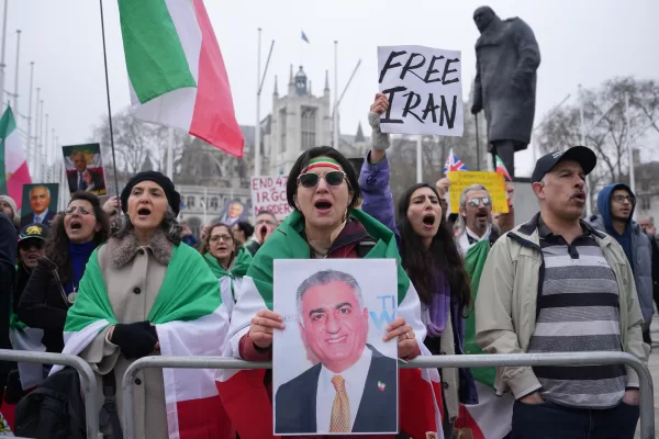 Protesters hold up placards showing Iran’s exiled crown prince Reza Pahlavi during a rally outside the parliament in London, Wednesday, March 4, 2026. (AP Photo/Kin Cheung)
