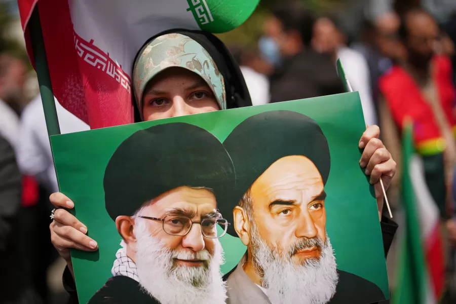 A woman holds a picture depicting the late Iran’s Supreme Leader Ayatollah Ali Khamenei, left, and the late revolutionary founder Ayatollah Ruhollah Khomeini during a government-sponsored protest attended by medical workers against the U.S.-Israeli military campaign outside Imam Khomeini Hospital in Tehran, Iran, Monday, April 6, 2026. (AP Photo/Francisco Seco)
