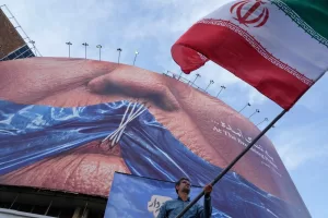 A man waves an Iranian flag for a pro-government campaign under a billboard with graphic showing Strait of Hormuz and sewn lips of U.S. President Donald Trump in a square in downtown Tehran, Iran, Wednesday, May 6, 2026. (AP Photo/Vahid Salemi) A man waves an Iranian flag for a pro-government campaign under a billboard with graphic showing Strait of Hormuz and sewn lips of U.S. President Donald Trump in a square in downtown Tehran, Iran, Wednesday, May 6, 2026. (AP Photo/Vahid Salemi)