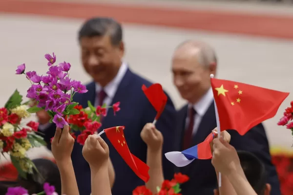 Children wave flags and flowers as Russian President Vladimir Putin, right, and Chinese President Xi Jinping attend a welcoming ceremony at the Great Hall of the People in Beijing Wednesday, May 20, 2026. (Maxim Shemetov/Pool Photo via AP)