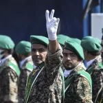 FILE – A member of Iran’s Basij paramilitary force flashes a victory sign during a military parade outside of Tehran, Iran, on Sept. 22, 2022. (AP Photo/Vahid Salemi, File)