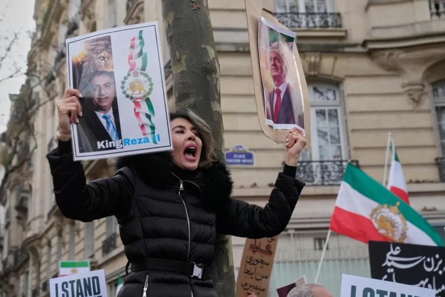 A protester holds posters of Reza Pahlavi during a rally in support of the nationwide mass demonstrations in Iran against the government in Paris, Sunday, Jan. 11, 2026. (AP Photo/Michel Euler)
