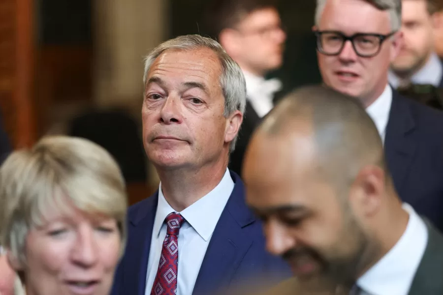 Reform UK Leader Nigel Farage walks through the House of Commons to attend the State Opening of Parliament at the Palace of Westminster, London, Wednesday, May 13, 2026. (Toby Melville/Pool Photo via AP)