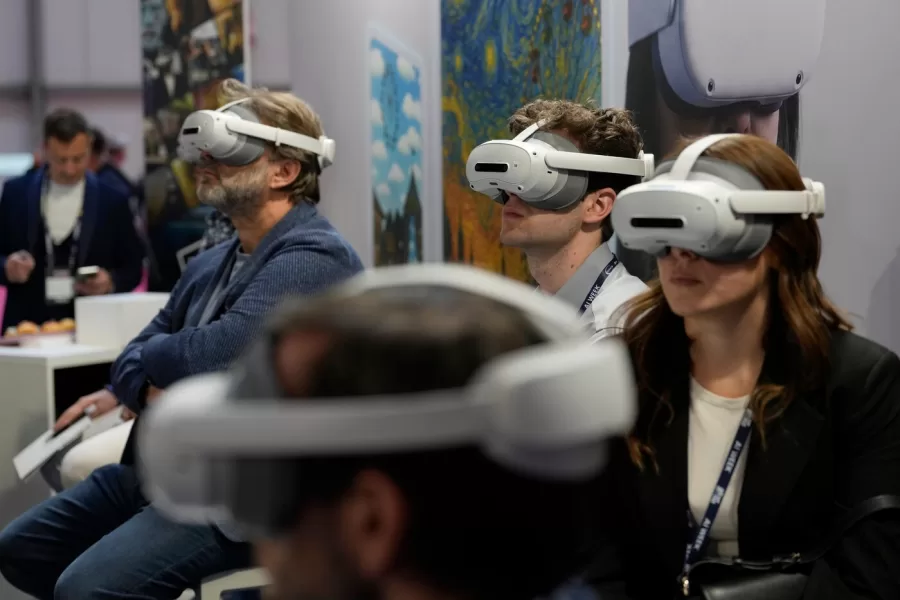Visitors try AI headset at the Europe’s largest artificial intelligence event, AI Week 2026, in Rho, near Milan, Italy, Tuesday, May 19, 2026. (AP Photo/Luca Bruno)