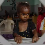 Four-year-old Farhia, who is suffering from severe acute malnutrition, looks through a window at a hospital in Qardho, Puntland, Somalia, Friday, April 17, 2026. (AP Photo/Jack Denton)