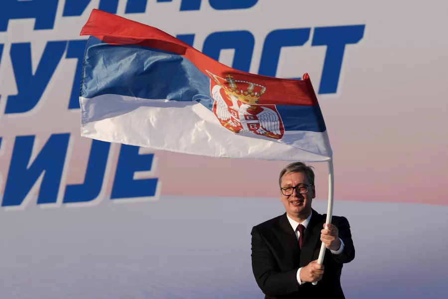 Serbian President Aleksandar Vucic waves a Serbian flag during a rally of the ruling Serbian Progressive Party (SNS) in Belgrade, Serbia, Saturday, June 27, 2026, where he announced that he will resign in the coming weeks. (AP Photo/Darko Vojinovic)