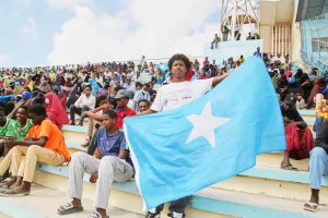 A man holds the flag of Somalia as people gather at the Mogadishu stadium while they protest Israel’s recognition of Somalia’s breakaway region of Somaliland as an independent nation, in Mogadishu, Somalia, Tuesday, Dec. 30, 2025. (AP photo/Farah Abdi Warsameh)