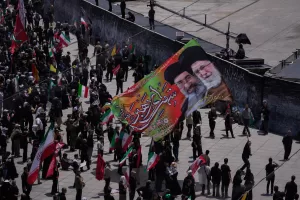 Mourners carry a large banner depicting the late Iranian Supreme Leader Ayatollah Ali Khamenei, right, and Iranian Supreme Leader Ayatollah Mojtaba Khamenei during the dayslong funeral ceremonies for the late supreme leader and members of his family outside the Imam Khomeini Mosalla Grand Mosque in Tehran, Iran, Sunday, July 5, 2026. (AP Photo/Altaf Qadri)