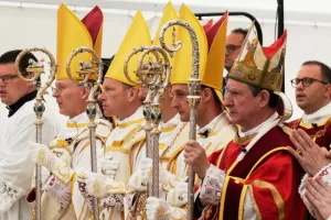 Newly consecrated Bishops, from left, Pascal Schreiber, Michael Goldade, Michel Poinsinet de Sivry and Marc Hanappier, wearing their miters and holding their pastoral staffs, stand at the end of their consecration ceremony in a tent set up outside the Society of St. Pius X seminary in Econe, Switzerland, Wednesday, July 1, 2026. (AP Photo/Baz Ratner)