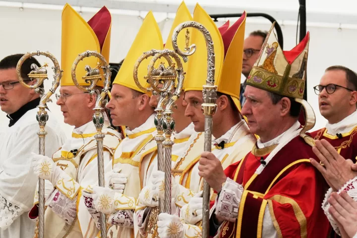 Newly consecrated Bishops, from left, Pascal Schreiber, Michael Goldade, Michel Poinsinet de Sivry and Marc Hanappier, wearing their miters and holding their pastoral staffs, stand at the end of their consecration ceremony in a tent set up outside the Society of St. Pius X seminary in Econe, Switzerland, Wednesday, July 1, 2026. (AP Photo/Baz Ratner)