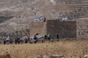 Israeli settlers put up Israeli flags on a Palestinian sturucture after it was taken down by Israeli and foreign peace activists during a protest in support of local landowners whose property is threatened with seizure by settlers, on the outskirts of the West Bank city of Beit Sahour, Friday, Aug. 14, 2026. (AP Photo/Mahmoud Illean) Israeli settlers put up Israeli flags on a Palestinian sturucture after it was taken down by Israeli and foreign peace activists during a protest in support of local landowners whose property is threatened with seizure by settlers, on the outskirts of the West Bank city of Beit Sahour, Friday, Aug. 14, 2026. (AP Photo/Mahmoud Illean)