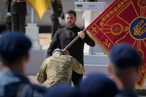 Ukraine’s President Volodymyr Zelenskyy hands over the flag of a military unit during the ceremony to mark Ukraine Independence Day in Kyiv, Ukraine, Monday, Aug. 24, 2026. (AP Photo/Efrem Lukatsky)